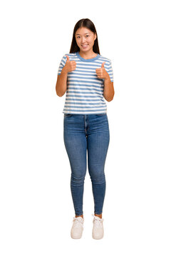 Young asian woman standing, full body cutout isolated raising both thumbs up, smiling and confident.