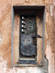 Fototapeta na wymiar Old broken intercom system in stone wall