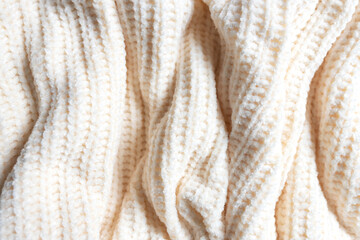 Fashionable knitted woolen fabric, abstract background. The texture of a soft warm sweater close-up. Knitted wool pattern