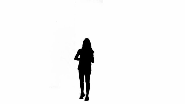 Black silhouette of female volleyball player hits ball on floor and then hits ball with her palm. Full length young woman on white isolated background. Practicing volleyball skills.