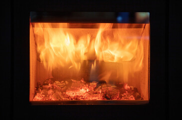 Fireplace close up, fire flame and burning wood logs, glass door fireside.