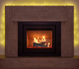 Naklejka premium Bonfire, burning fireplace, Christmas lights decoration. Energy wood logs fireside, front view.