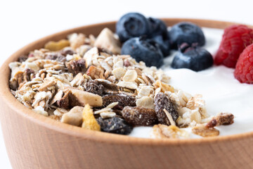 Yogurt with berries and muesli for breakfast in bowl. Close up