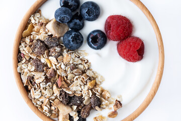 Yogurt with berries and muesli for breakfast in bowl. Close up