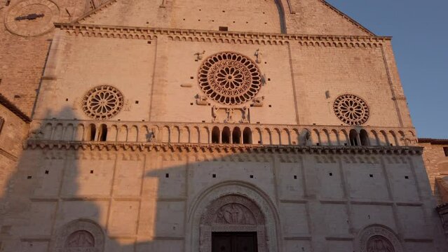 Romanesque façade of Assisi Cathedral of San Rufino  with its typical rose-window at sunset. Catholic church located in Umbria, a region in central Italy  Dolly move forward.