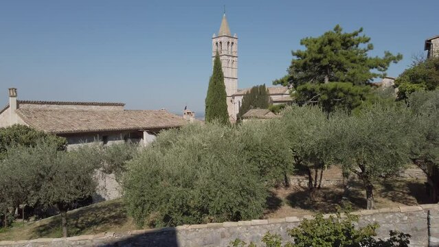 View on the bell tower of Basilica of Saint Clare in Assisi with lush foreground. It is one of the most important Basilica of that Umbrian town (Italy) dedicated to Saint Clare's religious order.