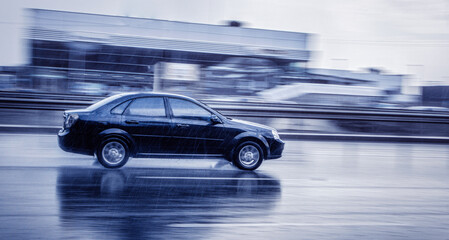 Fototapeta na wymiar A car is moving at high speed on the street in the rain.