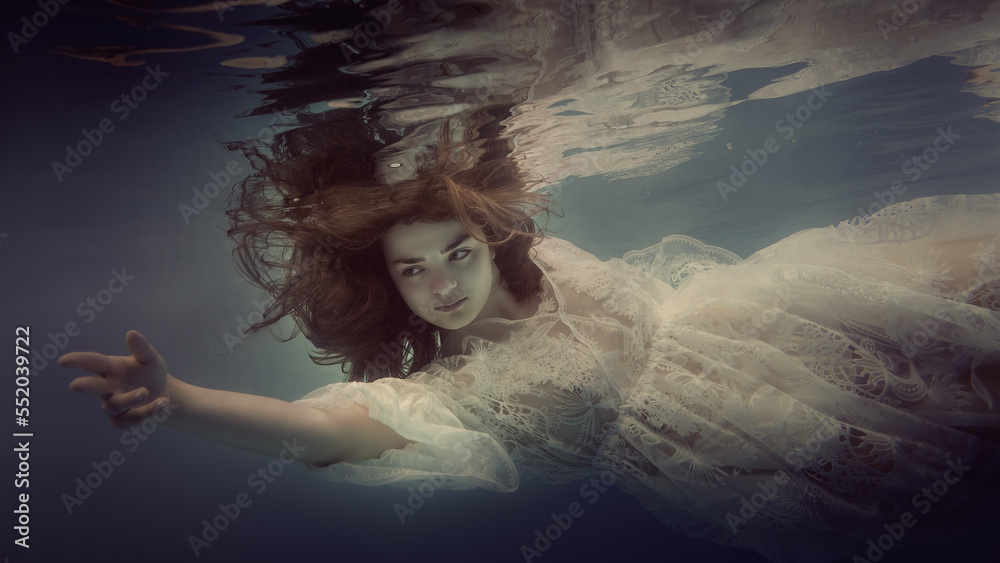 Wall mural portrait of a girl with dark hair in a lace dress underwater