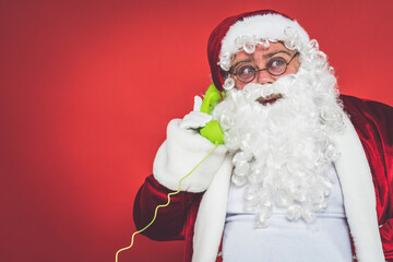 Funny crazy santa claus having fun on a red colored background