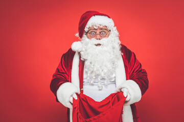 Funny crazy santa claus having fun on a red colored background