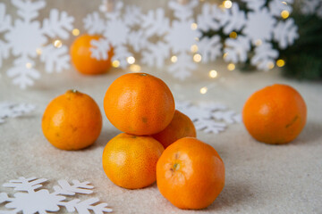 Fototapeta na wymiar tangerines and paper snowflakes on a wooden background