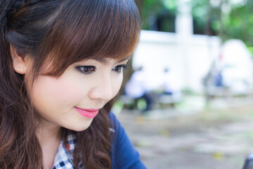 Asian woman doing makeup and smile happily.