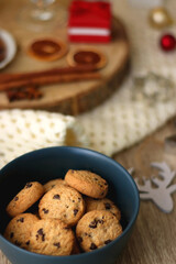 Various Christmas decorations, cup of tea or coffee, sweets, small presents, knitted blanket and candles. Selective focus.