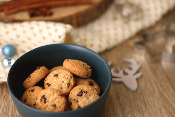 Various Christmas decorations, cup of tea or coffee, sweets, small presents, knitted blanket and candles. Selective focus.