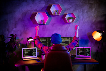 Photo of cheerful lucky guy dressed hat rising fists successful start up indoors workstation...