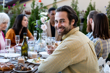 Family and friends celebrating at dinner on a rooftop terrace