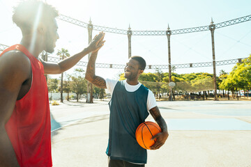 Young basketball players training at the court. Cinematic look image of friends practicing shots and slam dunks in an urban court © oneinchpunch