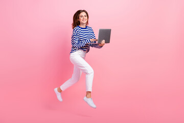 Full length portrait of excited pretty person jump rush use wireless netbook isolated on pink color background