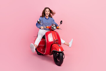 Fototapeta na wymiar Full length portrait of overjoyed pretty person have fun driving scooter isolated on pink color background