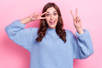 Portrait of overjoyed cheerful lady toothy smile hands fingers show v-sign near eye isolated on pink color background