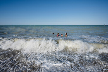 Family with kids swimming in Adriatic sea at beach Porto Sant Elpidio, Italy.