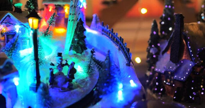 Shot of Christmas interior decoration on stage with skiing animatronics in view along with colorful lights lighting up the decortation.