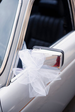 White ribbon wedding decoration on a vintage car