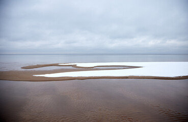 Fototapeta na wymiar Winter photo on Baltic sea coast with some snow on the shoal, selective focus