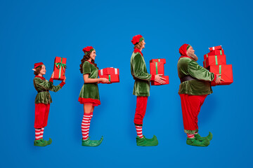 Full body photo of line santa service people different age hold giftboxes wear new year costumes...