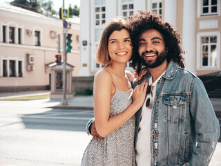 Smiling beautiful woman and her handsome boyfriend. Sexy cheerful multiracial family having tender moments in the street at sunset. Multiethnic models hugging. Embracing each other. Love concept