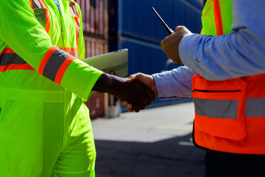 Worker Foreman In Safety Hard Hat Shaking Hands With Logistics Worker At Cargo Containers Yard, Import And Export Business