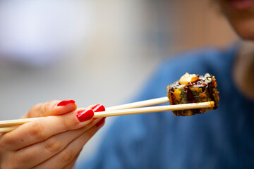 Eating amazing sushi with chopsticks.