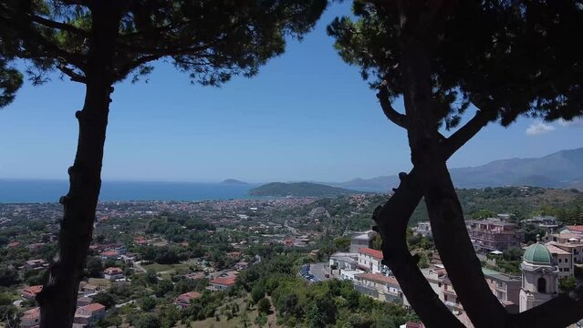 Exotic coastal city of Formia in Italy, motion forward view through trees. Birds flying