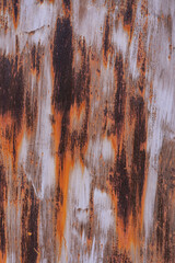 Metal surface with traces of rust and faded paint. Bright brown rust on a metal surface.