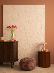 Minimalist composition of living room interior with mock up poster frame, wooden sideboard, stand, vase with pink flowers, lamp, pouf, beige rug, box and personal accessories. Home decor. Template.