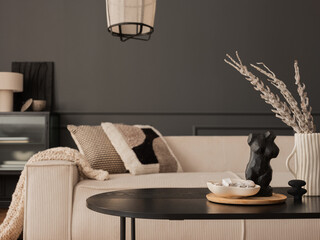 Creative composition of living room interior with modular beige sofa, black coffee table, vase with...