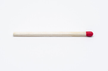 One single new unlit matchstick on white background