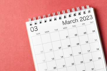 A March 2023 calendar desk for the organizer to plan and reminder isolated on red background.