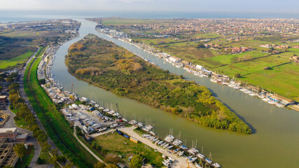Aerial view on the Holy Isle located in Fiumicino, Italy. It' s an artificial island on the Tiber River, near Rome. Many boats are anchored.