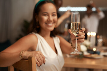 Woman, champagne and hand for toast in portrait, dinner or party for new year with friends, family or team. Happy celebration, sparkling wine or smile at supper for food, drinks or blurred background