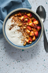 Greek yogurt with peaches and quinoa popcorn in a blue bowl on a blue tablecloth background