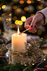 Young girl lighting a candle for Christmas dinner - 552072356