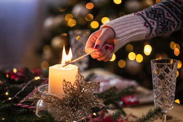 Young girl lighting a candle for Christmas dinner - 552072360