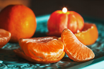 A burning candle in the shape of a tangerine. Holiday advent. Beautiful handmade candles.