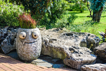 Sochi, Russia, August 13 -2022 Sochi-Park. Lonely flowerbed standing in resort park attracts visitors with funny expression. Stone flowerbed illuminated by bright sunlight