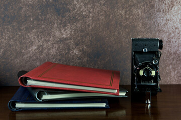 Photo Albums and Old Folding Camera on a Polished Wooden Surface
