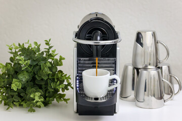Coffee corner at home, espresso machine on the bar making fresh espresso coffee into white cup....
