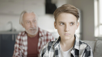 Sad boy ignoring his shouting grandfather, generation gap, misunderstanding