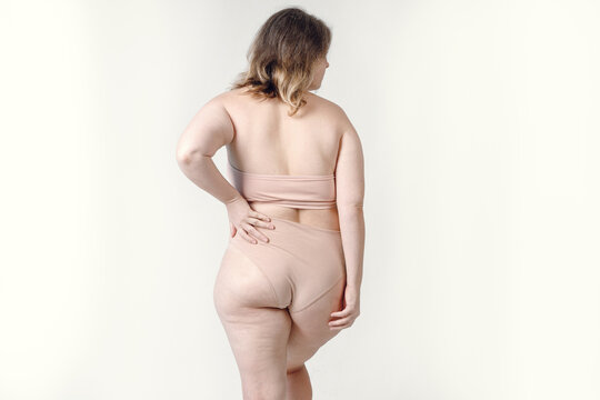 An Overweight Plus-size Woman With Stretch Marks On Her Skin, Standing In White Underwear. Women's Thick Thighs Close-up, Body Acceptance.