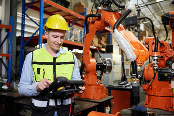 factory worker or engineer operating remote switch controller to control robot machine in the...